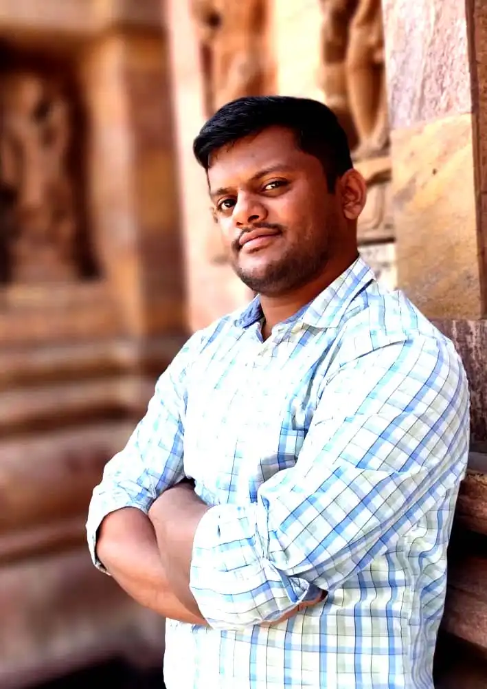 satyajit smiling in a white shirt in a temple